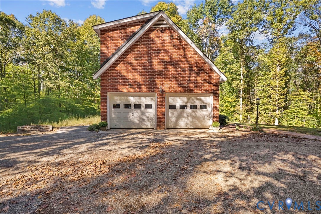 12082 Victoria Hills Road, Rockville, VA 23146 Detached two-car garage featuring a red brick exterior, a gabled roofline, and white overhead doors with rectangular window inserts