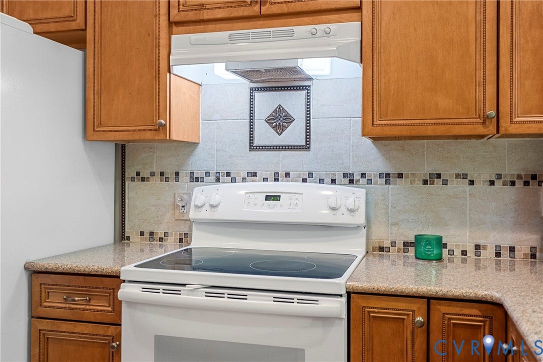 12082 Victoria Hills Road, Rockville, VA 23146 Kitchen featuring wood cabinetry, stone-finish countertops, tile backsplash with decorative inset, and a built-in range hood
