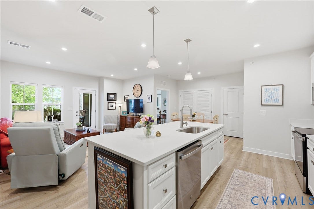 15801 Hallowell Ridge, #304, Moseley, VA 23120 Open-concept living space with recessed lighting, wood-finish flooring, a kitchen island featuring an integrated sink, and stainless steel appliances