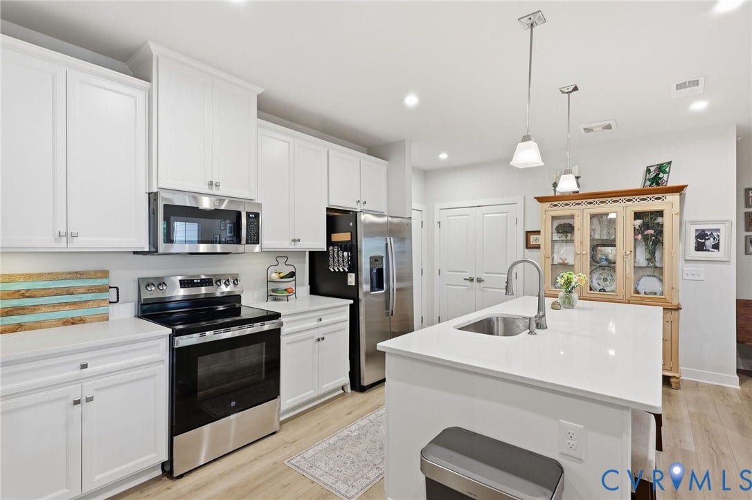 15801 Hallowell Ridge, #304, Moseley, VA 23120 Kitchen featuring white cabinetry, stainless steel appliances, a center island with sink, pendant lighting, and wood-finish flooring