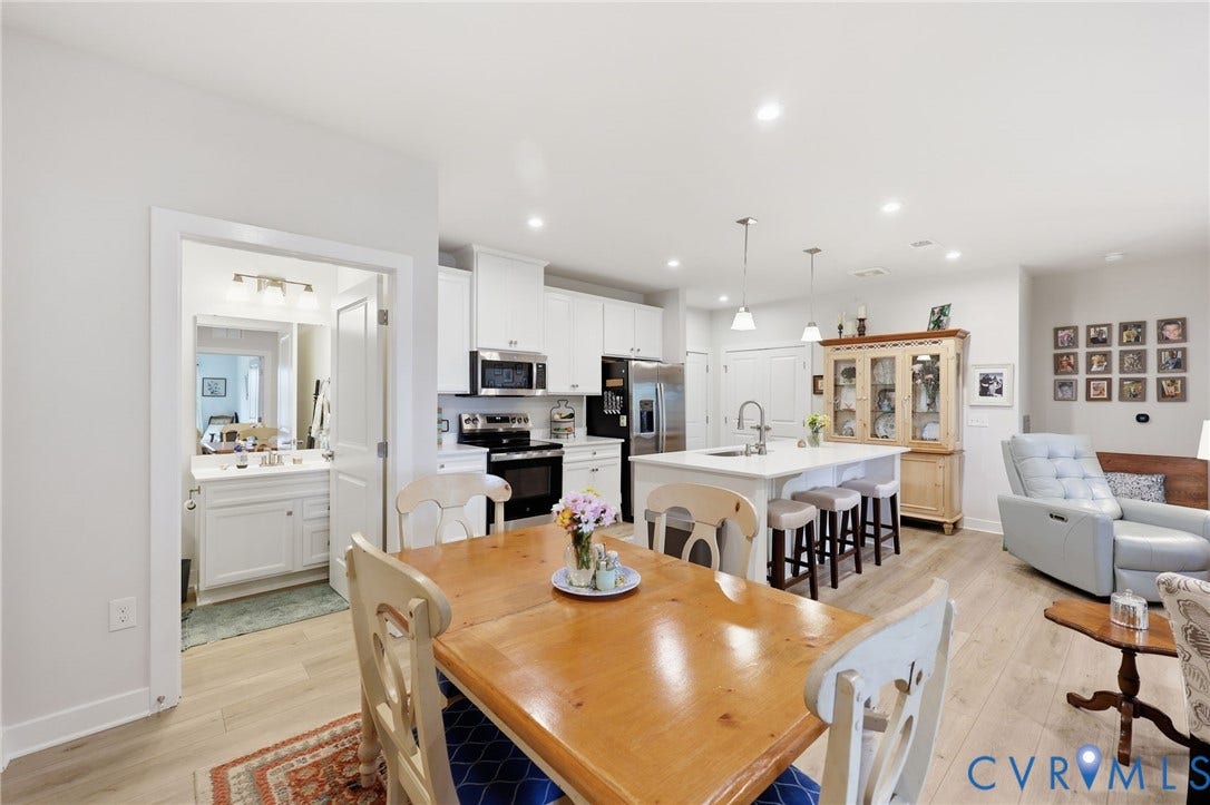 15801 Hallowell Ridge, #304, Moseley, VA 23120 Open-concept living area with wood-finish flooring, recessed lighting, a kitchen island with seating, white cabinetry, and stainless steel appliances