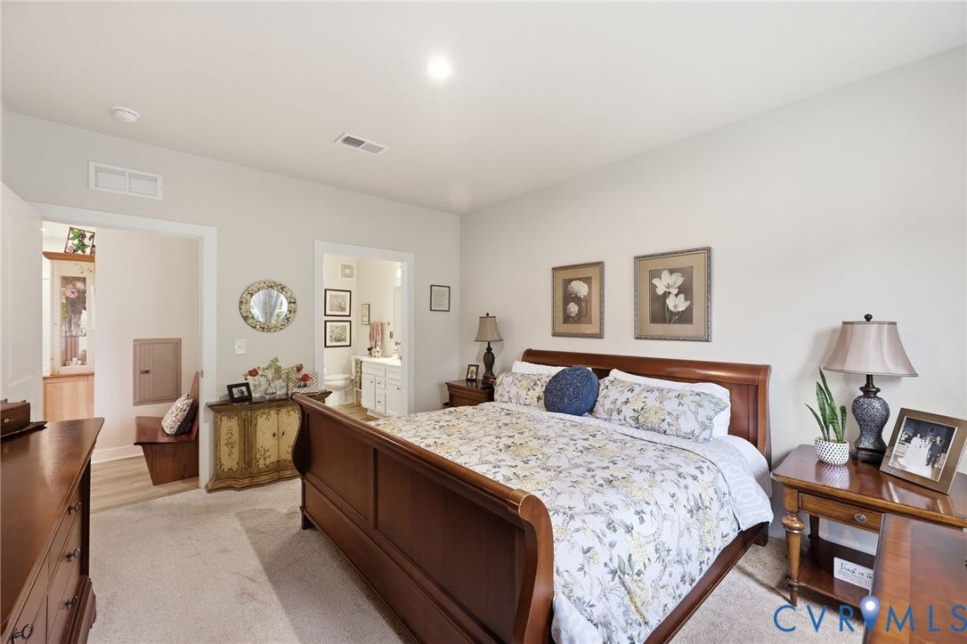 15801 Hallowell Ridge, #304, Moseley, VA 23120 Plush carpet flooring, recessed lighting, and a neutral wall color complement the spacious interior, with a partially visible bathroom featuring a vanity