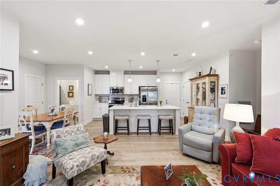 15801 Hallowell Ridge, #304, Moseley, VA 23120 Open-concept living space featuring wood-finish flooring, recessed lighting, a kitchen island with pendant lights, white cabinetry, and stainless steel appliances