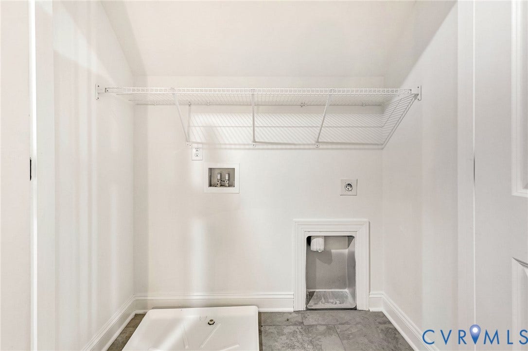 Laundry area featuring a utility sink, a wall-mounted wire shelf, tile flooring, and white baseboards