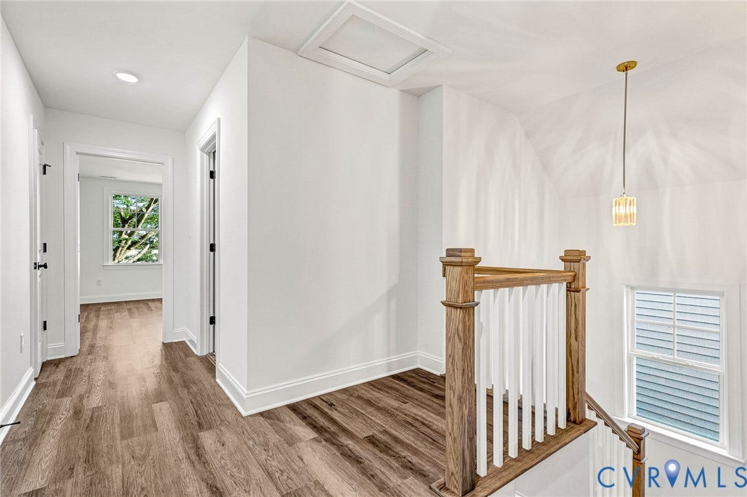 Wood-finish flooring throughout, recessed lighting, and a modern pendant fixture illuminate this space