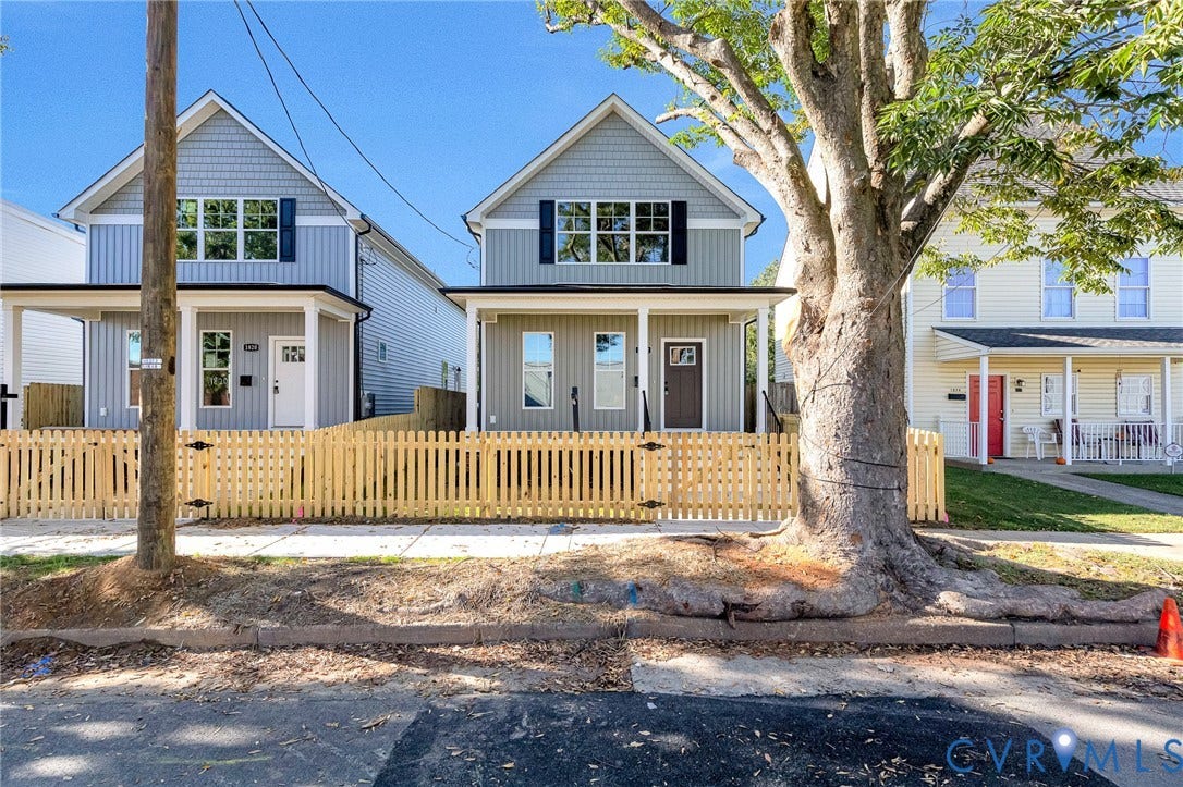 New construction residence with board and batten siding, shaker siding, a covered front porch, and a picket fence