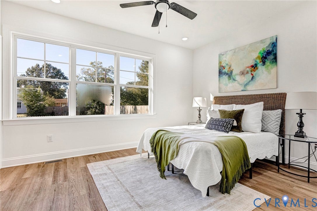 Bright, light-filled bedroom with triple-window configuration providing natural illumination and outdoor sightlines