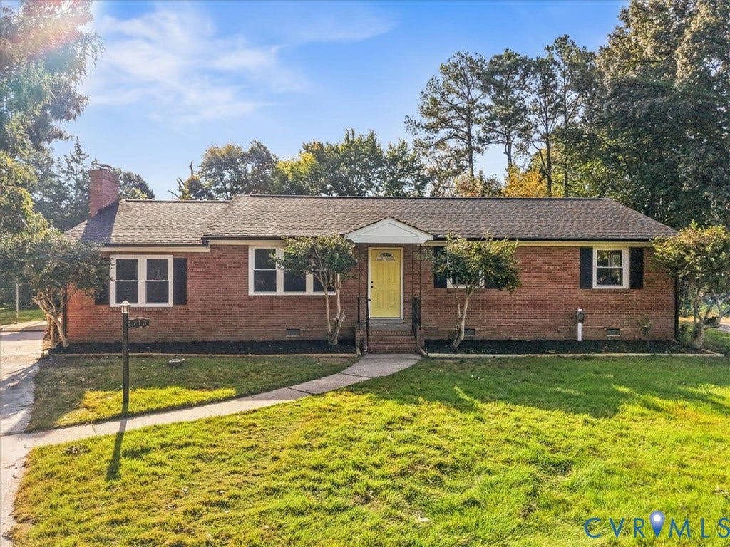 Brick exterior with a gabled roof and a vibrant yellow entry door