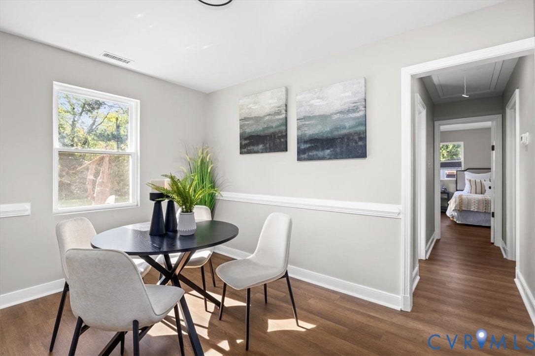 Wood-finish flooring, white trim, single pane window, and light gray walls