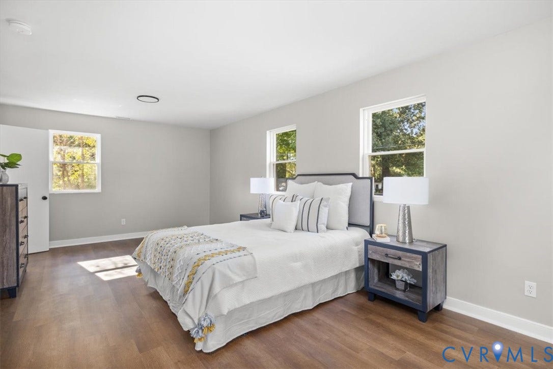 Wood-finish flooring throughout, bright walls, and multiple windows
