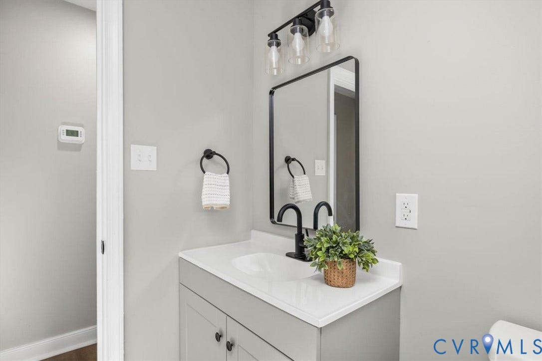 Vanity with a white countertop, under-mount sink, and matte black faucet