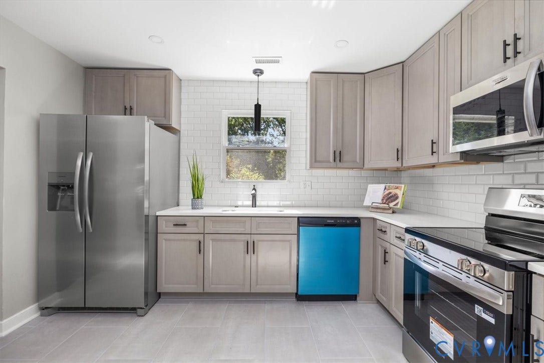 Kitchen featuring light gray cabinetry, stainless steel appliances, white subway tile backsplash, white countertops, and gray tile flooring