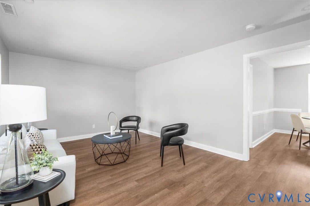 Wood-finish flooring throughout, light gray wall finishes, and white trim