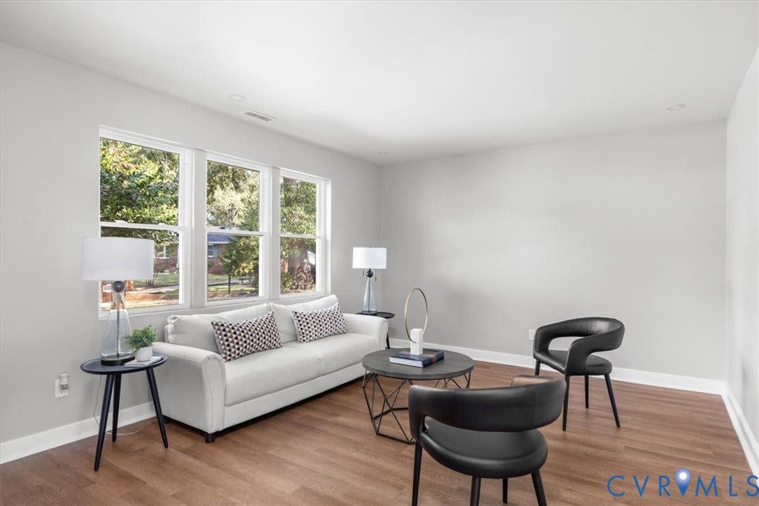 Wood-finish flooring, light gray wall paint, white trim, and multiple large windows