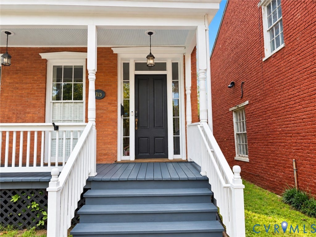 315 Grove Avenue, Petersburg, VA 23803 Brick exterior with a covered porch, white columns, dark gray porch steps, white railing, and a dark paneled entry door