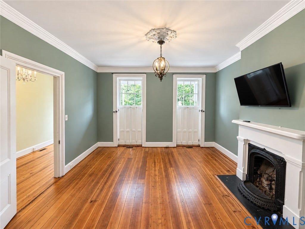 315 Grove Avenue, Petersburg, VA 23803 Hardwood flooring throughout, crown molding, built-in fireplace with a white mantel, and two paneled doors with upper windows