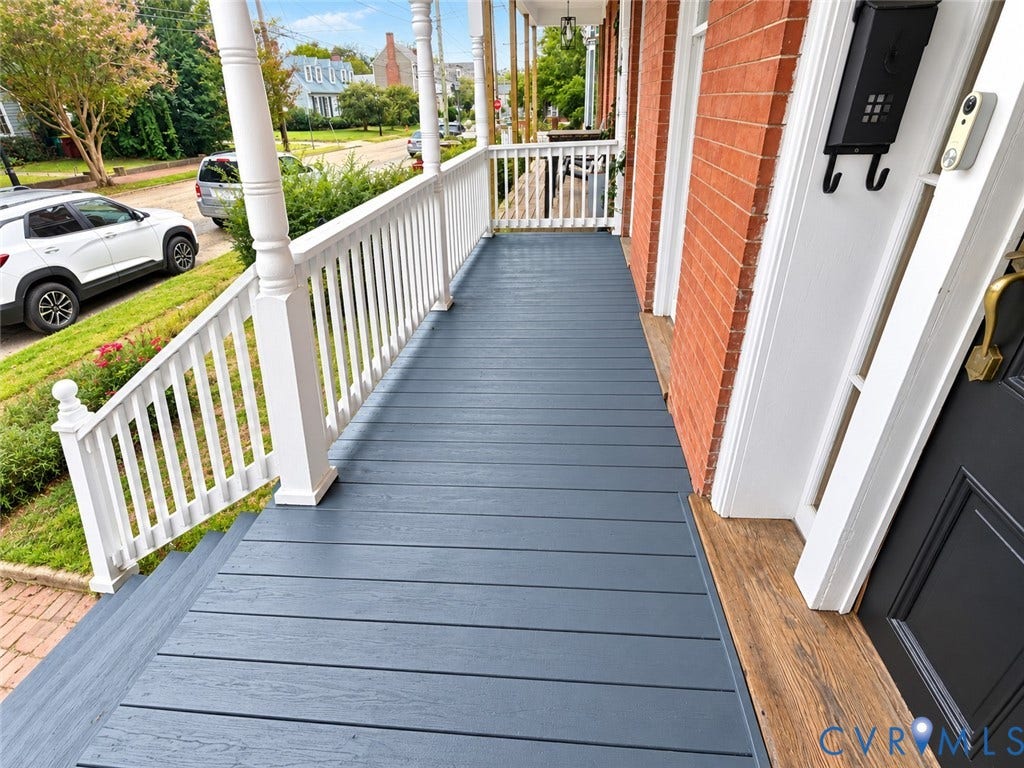 315 Grove Avenue, Petersburg, VA 23803 Expansive front porch featuring gray wood-finish decking, white railings, and brick exterior