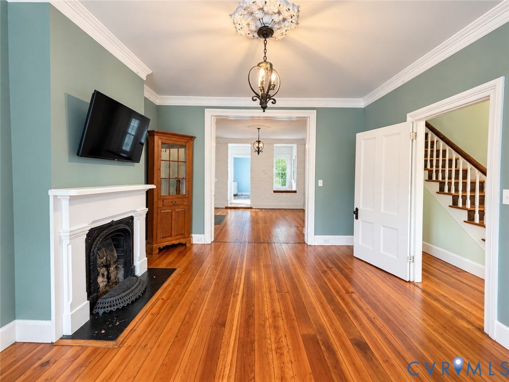 315 Grove Avenue, Petersburg, VA 23803 Hardwood flooring throughout, a white mantel fireplace, intricate ceiling light fixture, and crown molding