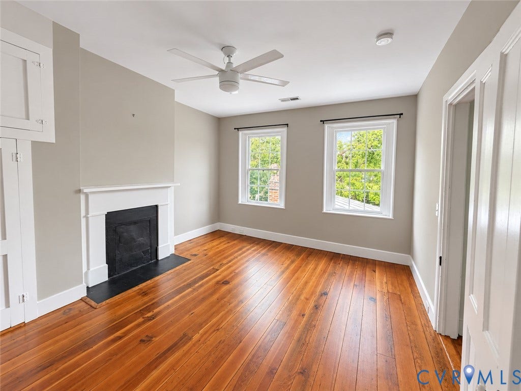315 Grove Avenue, Petersburg, VA 23803 Hardwood flooring, white trim, classic fireplace, ceiling fan, and two windows
