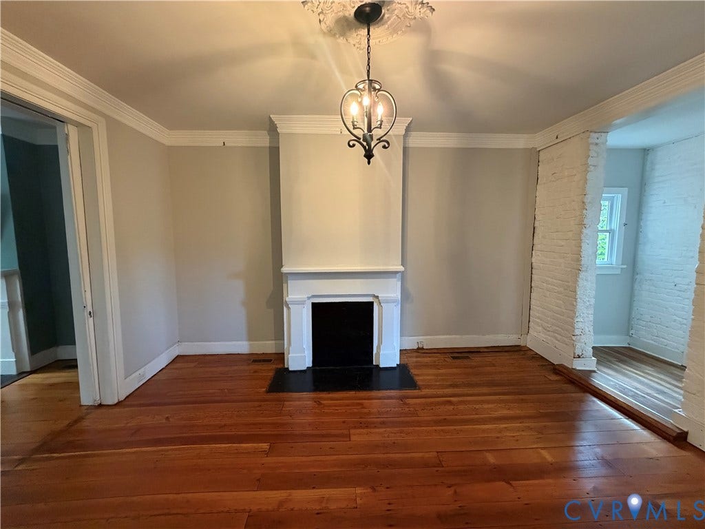 315 Grove Avenue, Petersburg, VA 23803 Hardwood flooring, decorative ceiling medallion, fireplace with white mantel, black hearth, and exposed brick wall