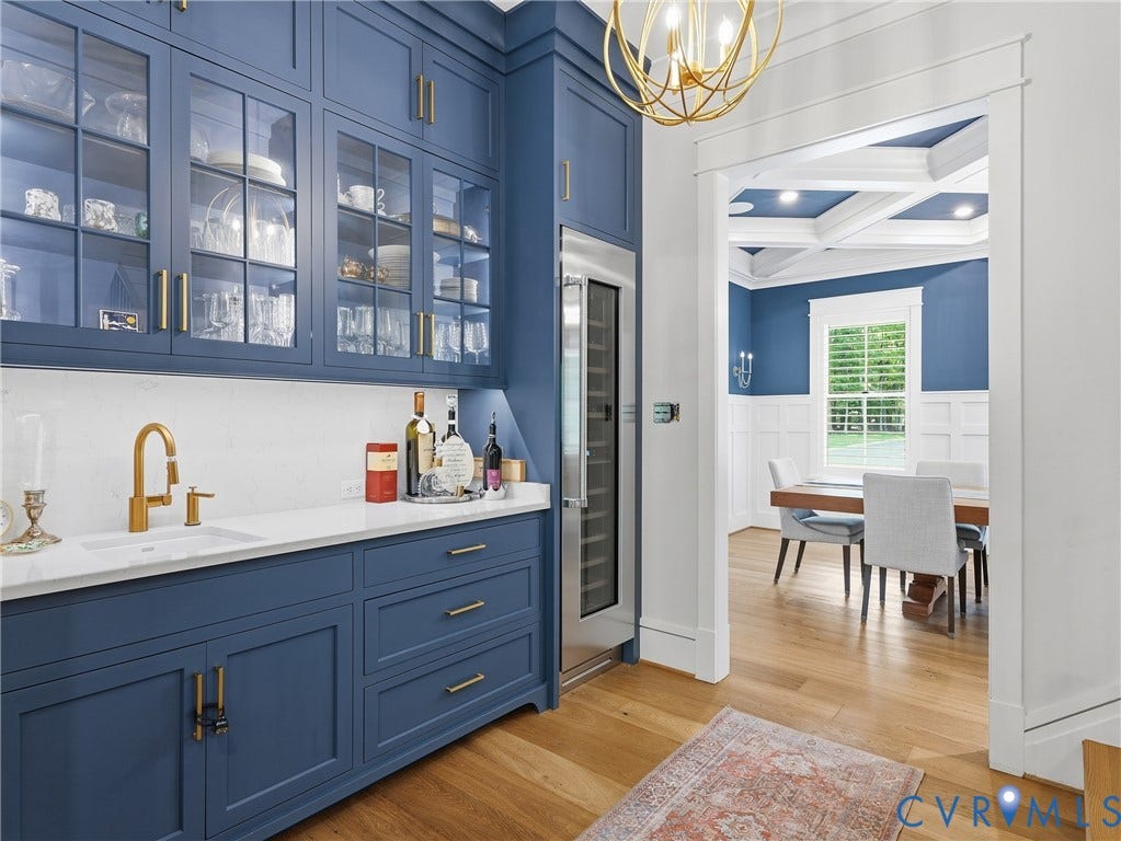 Built-in cabinetry with glass-front uppers and a beverage refrigerator