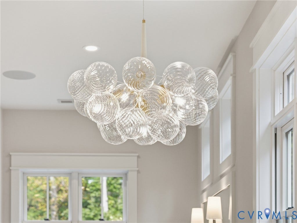 Multi-globe chandelier with textured glass spheres and metallic finish hardware, featuring recessed lighting and paneled windows with detailed millwork