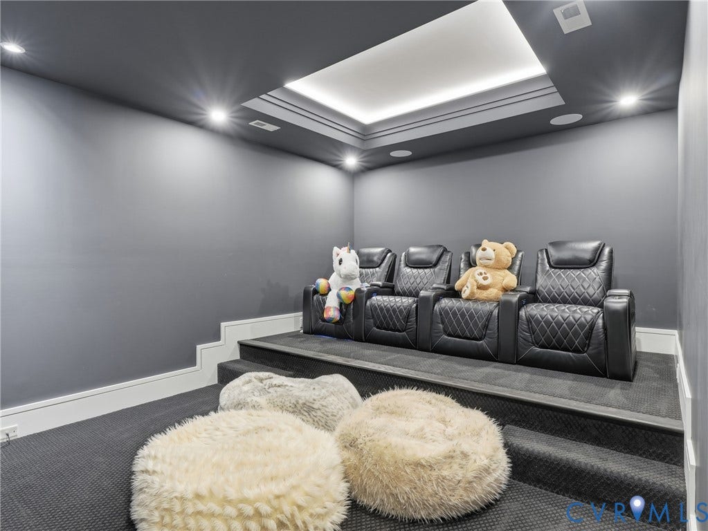 Tiered seating area with recessed ceiling lighting, wall-mounted speakers, and wall-to-wall carpeting