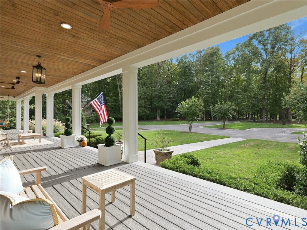 Expansive covered porch featuring a wood-panel ceiling, recessed lighting, and a durable composite deck surface