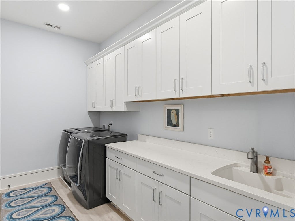 Extensive white cabinetry, integrated sink, and light-toned countertop