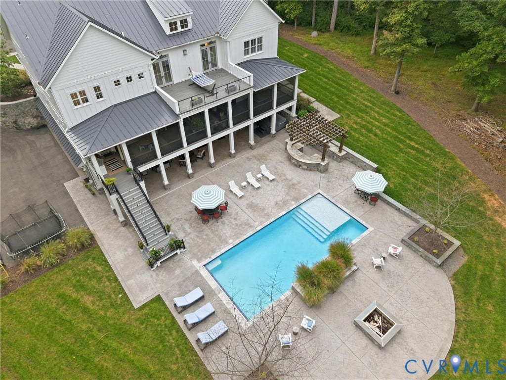 White siding home with a dark metal roof, featuring a screened porch and upper-level balcony