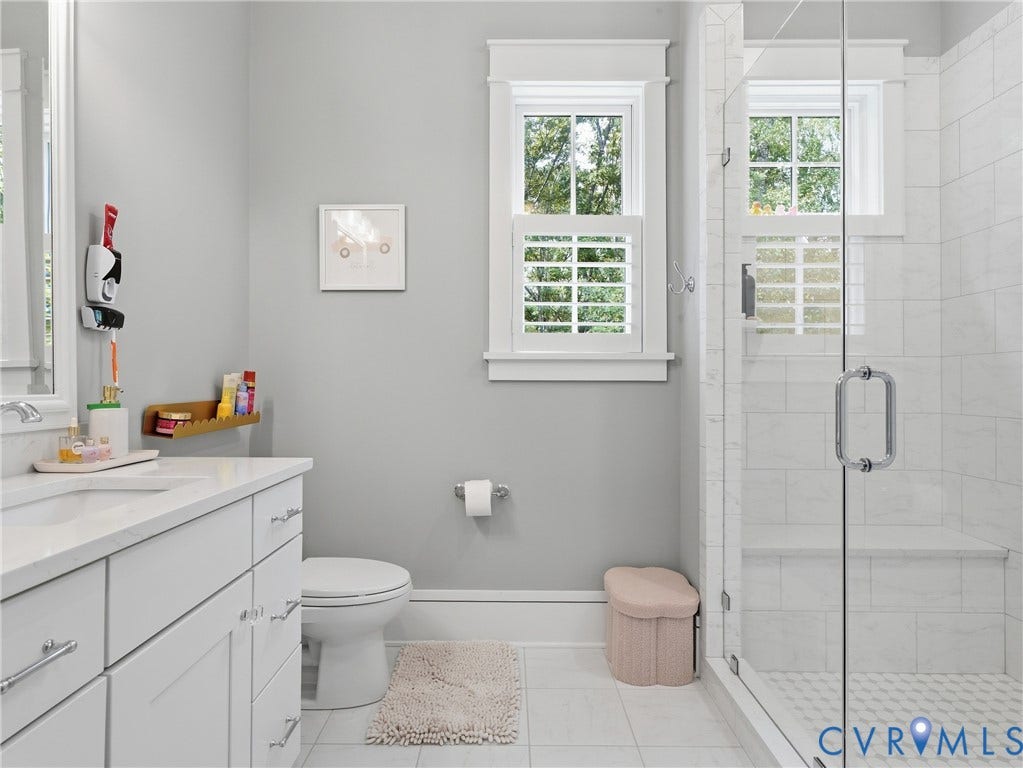 White vanity with a solid surface countertop, undermount sink, and chrome fixtures