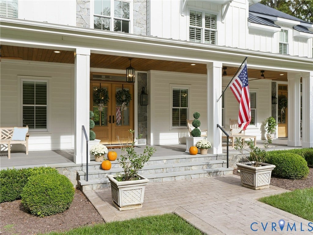 Expansive front porch with substantial white columns and a natural wood-finish ceiling