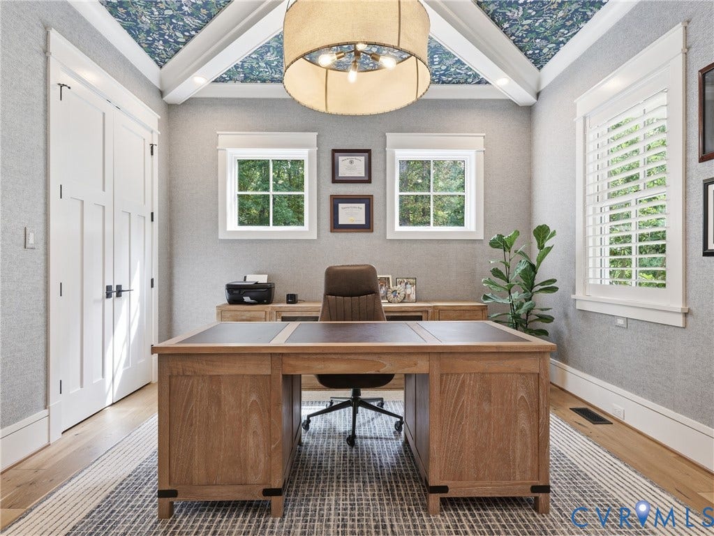 Coffered ceiling office  with Rifle Paper Co decorative wallpaper, exposed beams, and a drum-style chandelier