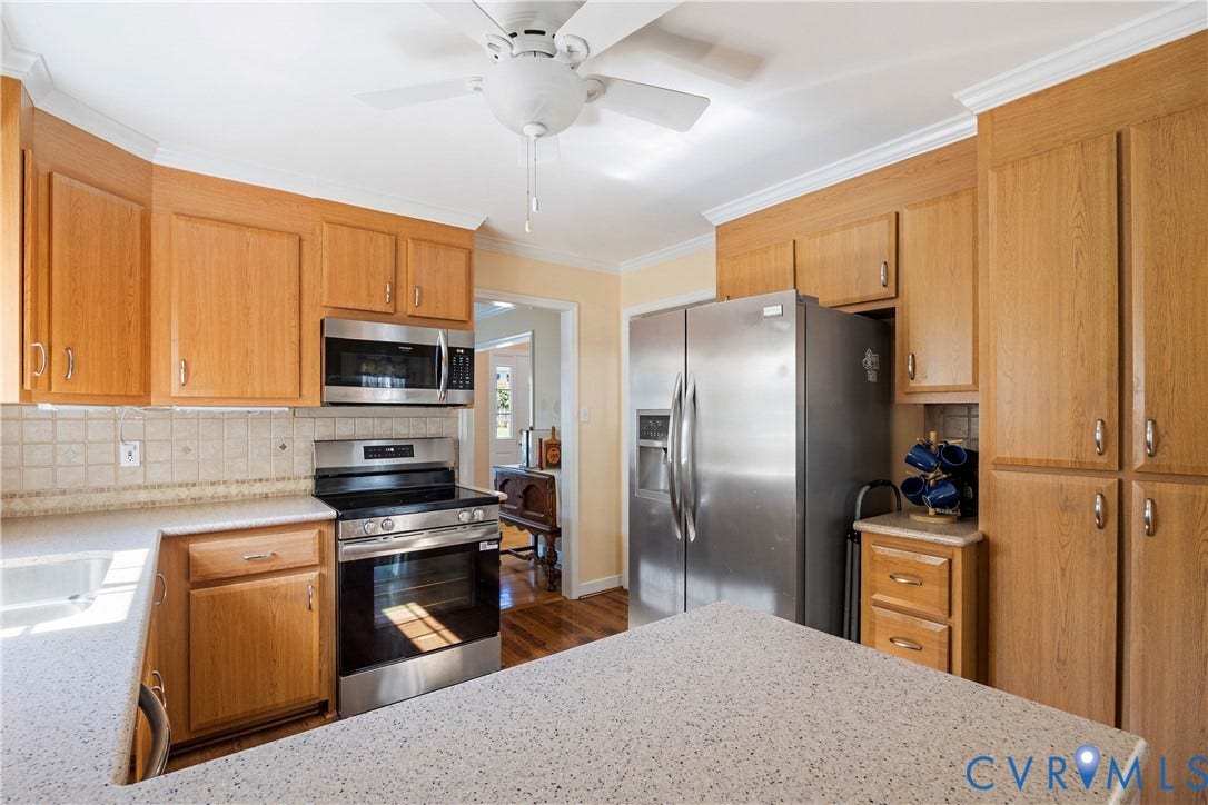 717 McCauliff Drive, Chesterfield, VA 23236 Kitchen featuring natural wood cabinetry, stainless steel appliances, tile backsplash, and light-toned countertops