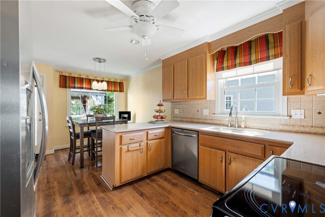 717 McCauliff Drive, Chesterfield, VA 23236 Kitchen featuring wood-finish flooring, light wood cabinetry, stainless steel dishwasher, light-toned countertops, and a tile backsplash