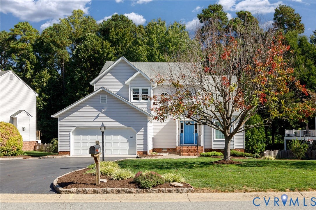 717 McCauliff Drive, Chesterfield, VA 23236 Siding exterior with a two-car garage, paved driveway, and a front yard featuring mature trees and landscaping