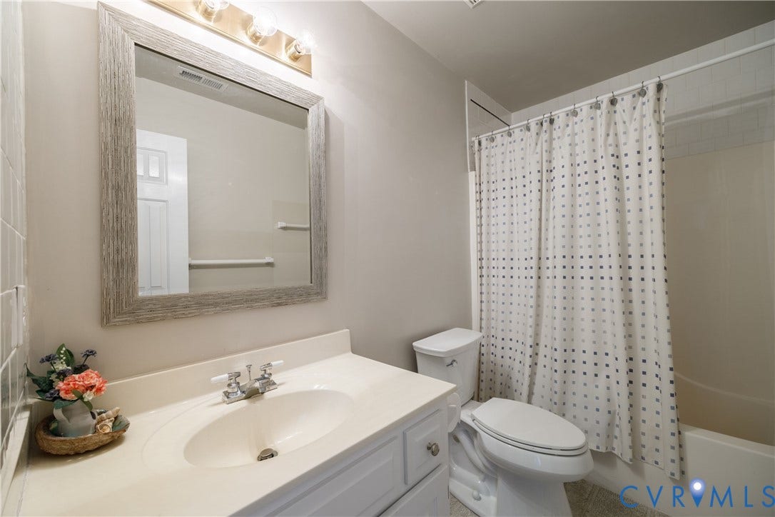 717 McCauliff Drive, Chesterfield, VA 23236 White vanity with integrated sink, chrome faucet, and a large framed mirror