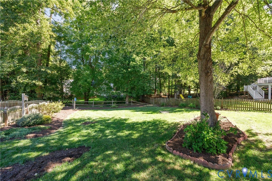 717 McCauliff Drive, Chesterfield, VA 23236 Spacious grass lawn with a mature shade tree, perimeter fencing, and established garden beds