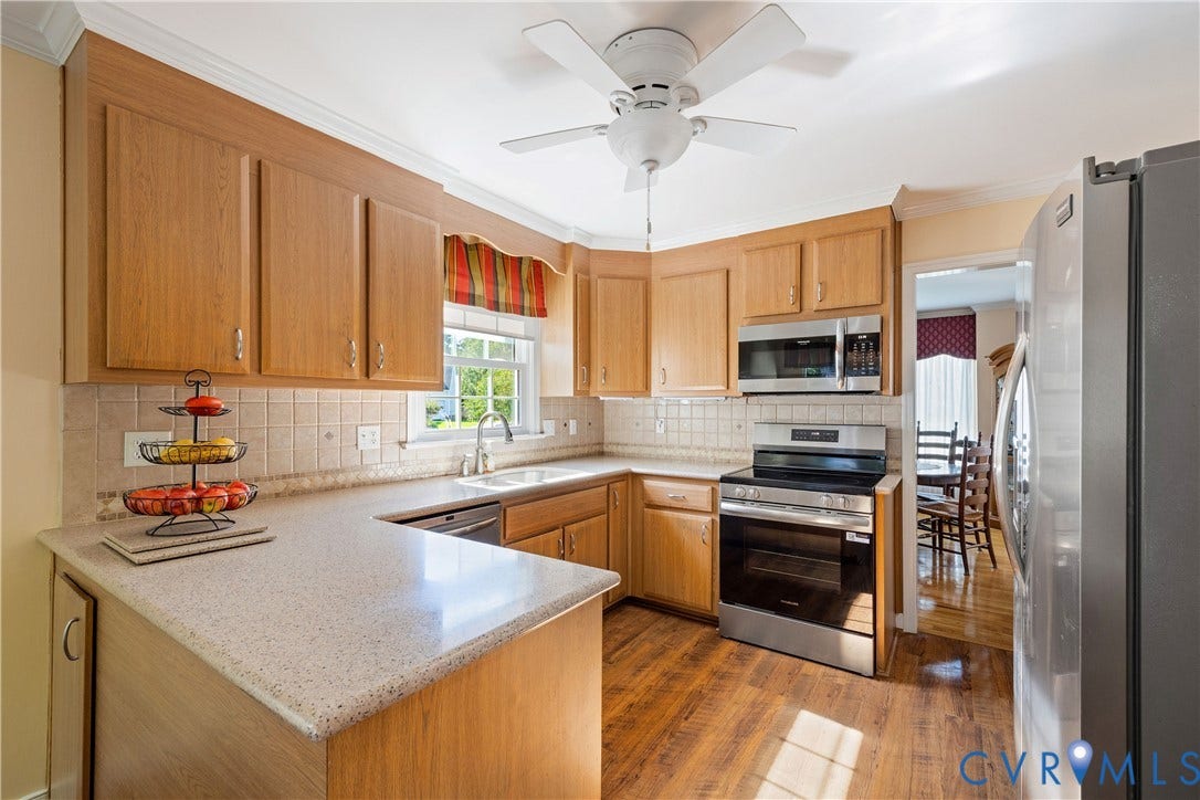 717 McCauliff Drive, Chesterfield, VA 23236 Kitchen featuring wood-finish flooring, light-toned cabinetry, a stainless steel range, a stainless steel microwave, and light-toned countertops