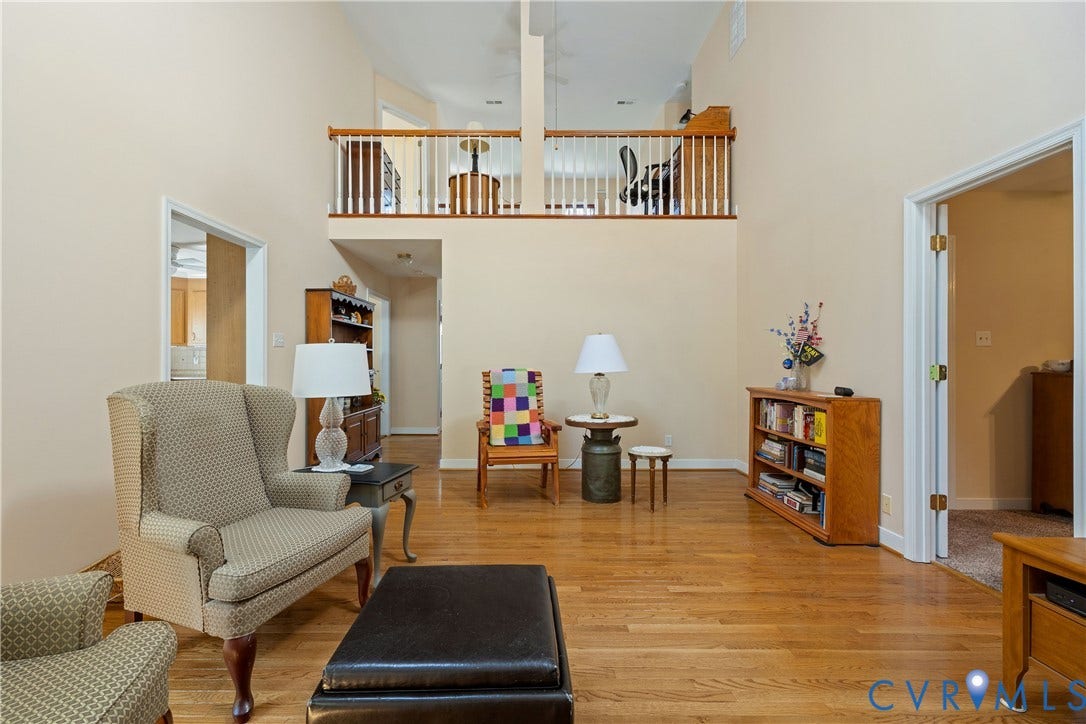 717 McCauliff Drive, Chesterfield, VA 23236 Two-story living area with hardwood flooring, a second-story open railing, and neutral wall tones