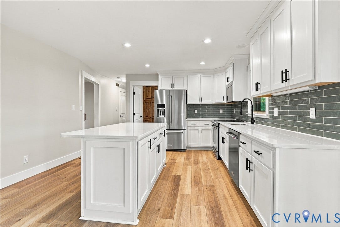 17 River Walk, Cumberland, VA 23027 Kitchen featuring white cabinetry with black hardware, stainless steel appliances, a subway tile backsplash, and light wood-finish flooring