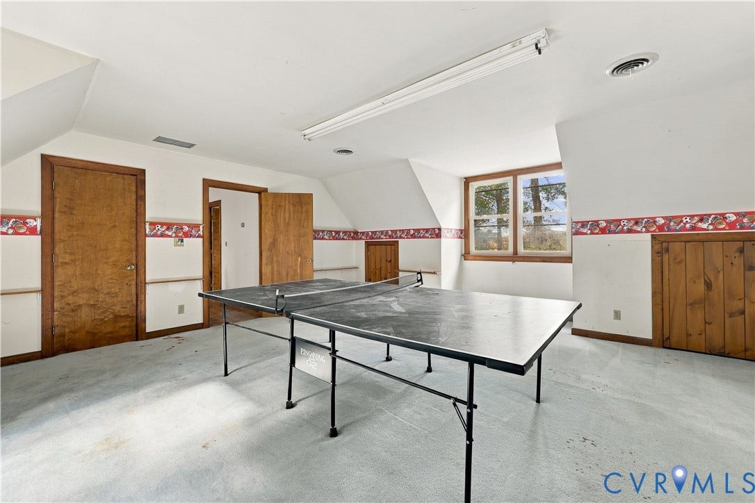 17 River Walk, Cumberland, VA 23027 Attic space with sloped ceilings, multiple wood-paneled doors, wood-framed windows, and track lighting