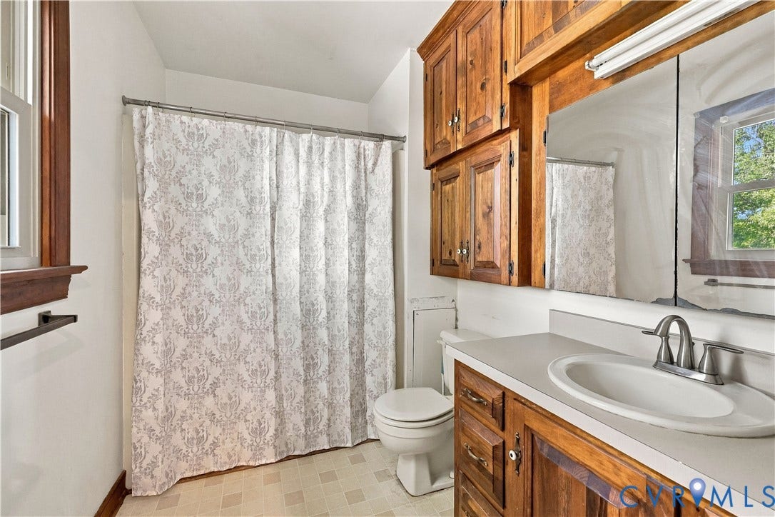 17 River Walk, Cumberland, VA 23027 Bathroom featuring a single vanity, wood-finish cabinetry, built-in medicine cabinet, and a window with wood-finish trim