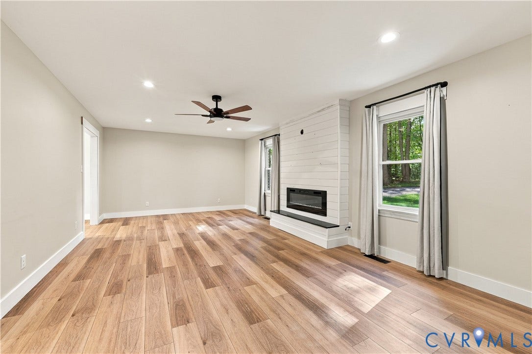 17 River Walk, Cumberland, VA 23027 Expansive room featuring wood-finish flooring, a contemporary fireplace with a shiplap surround, and recessed lighting