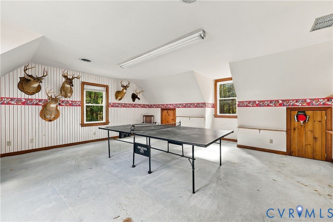 17 River Walk, Cumberland, VA 23027 Attic space featuring sloped ceilings, two windows with wood trim, and built-in wood cabinetry
