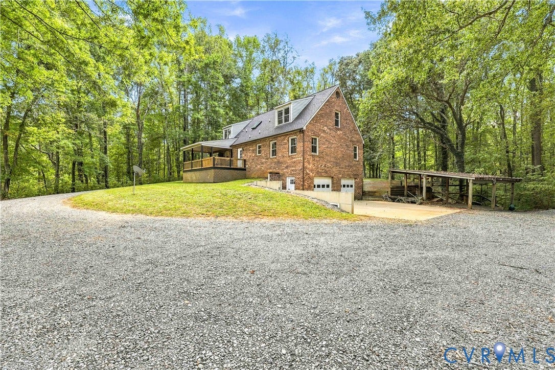 17 River Walk, Cumberland, VA 23027 Brick facade home with a two-car garage, covered deck, and a detached open-air shelter