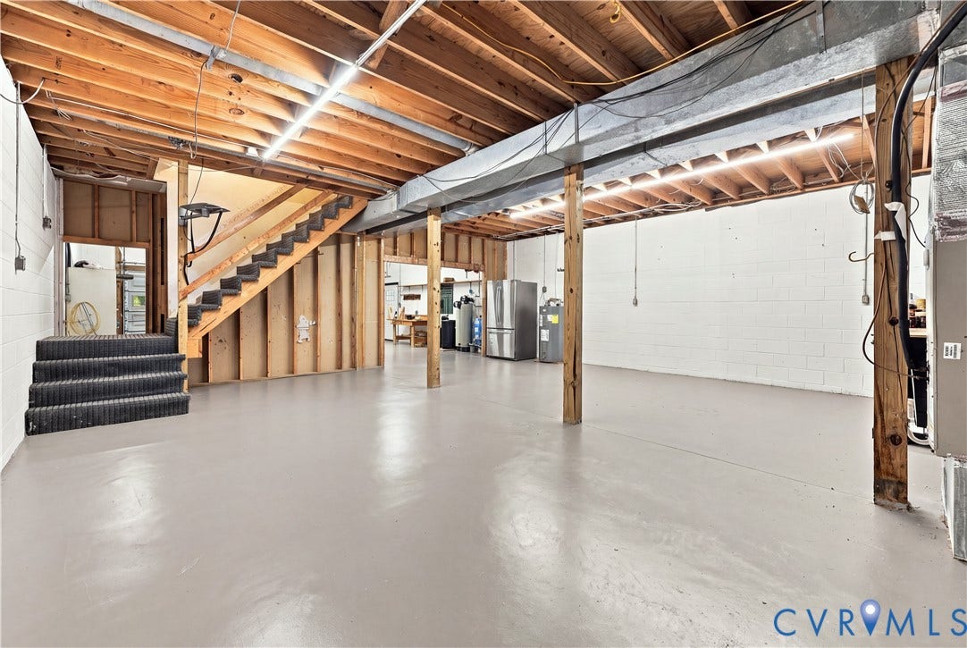 17 River Walk, Cumberland, VA 23027 Expansive unfinished basement featuring an exposed wood joist ceiling, painted concrete flooring, and an open wood staircase
