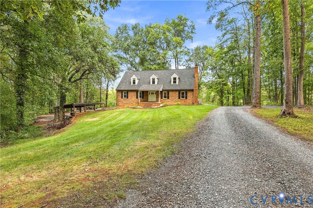 17 River Walk, Cumberland, VA 23027 Brick exterior with dormer windows, a gravel driveway, and a sloped lawn