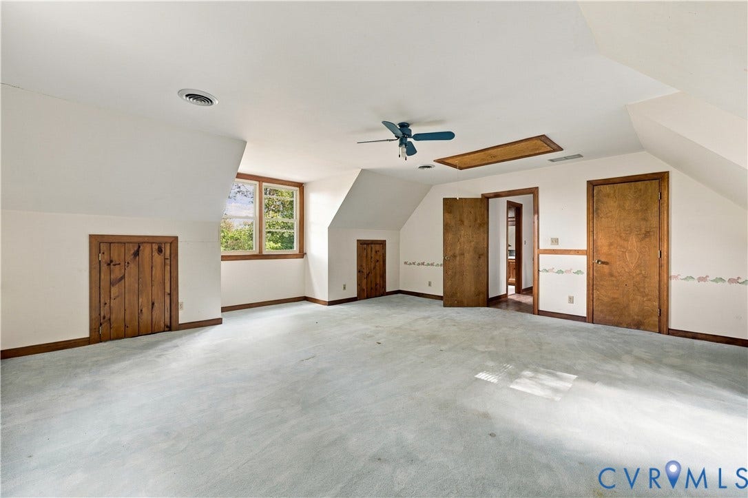 17 River Walk, Cumberland, VA 23027 Spacious room featuring sloped ceilings, a ceiling fan, and multiple wood-paneled doors