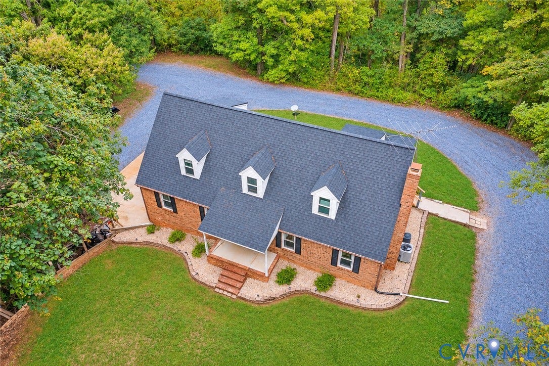 17 River Walk, Cumberland, VA 23027 Brick exterior with three dormer windows, a covered front porch, and a gravel driveway